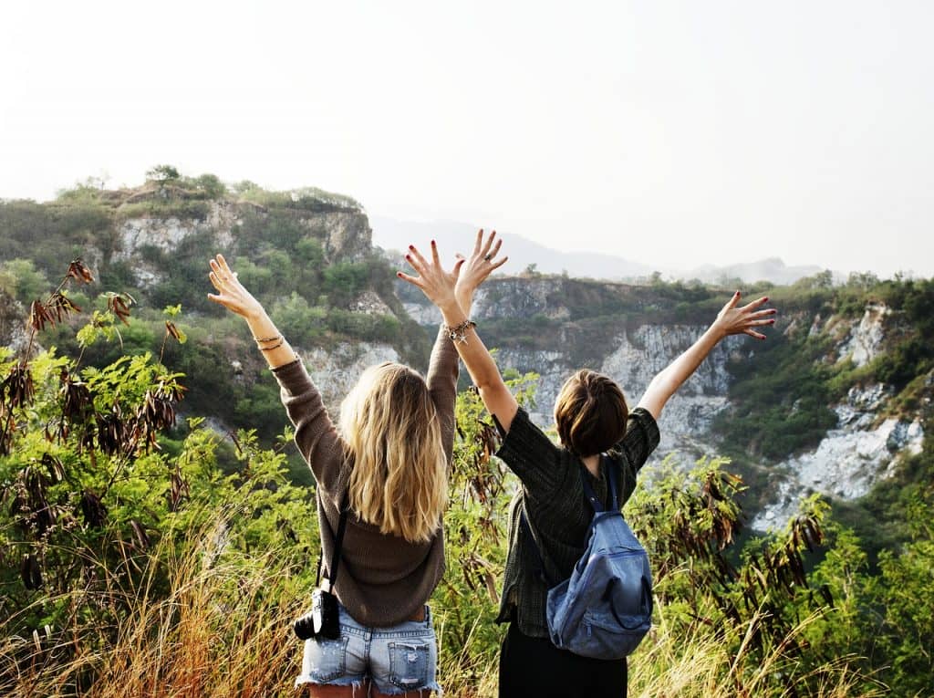 Two happy girls enjoying mountain view