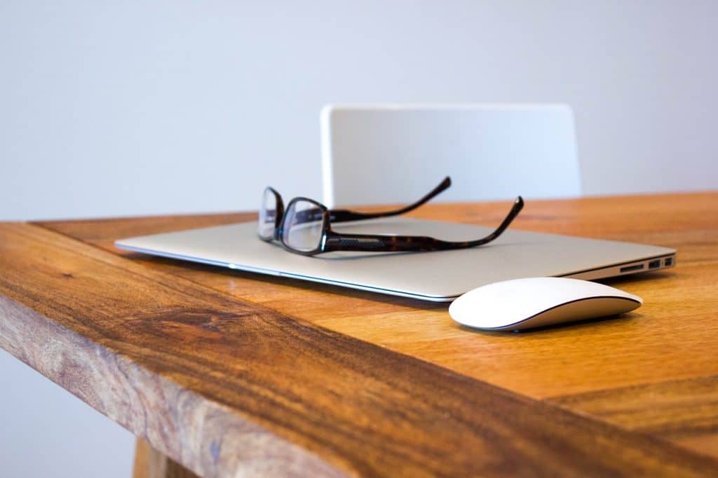 Laptop, glasses and mouse on table